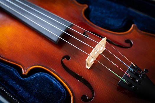 Close up of a syphony violin set against a black background