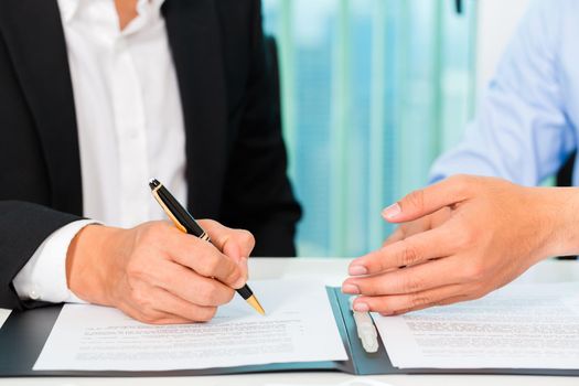 business people signing agreement in office