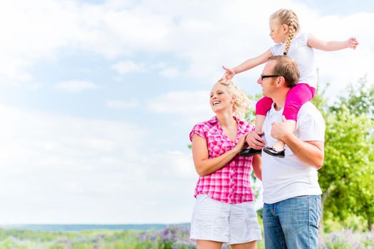 Family having summer walk on meadow outdoors