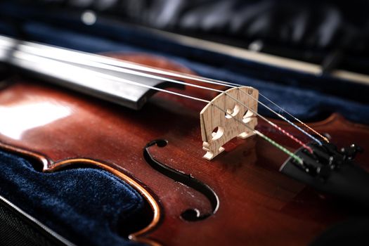 Close up of a syphony violin set against a black background