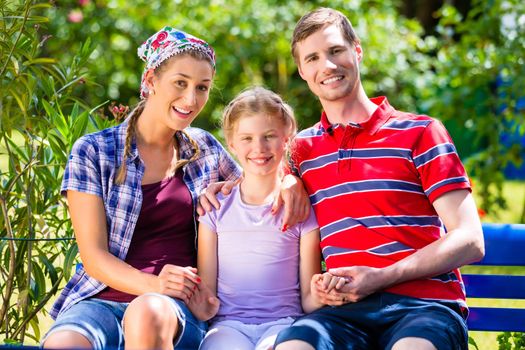 Family in garden sitting on bench