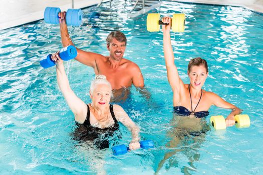 Group of people, mature man, young and senior women, at water gymnastics or aquarobics