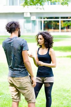 Couple, Latin man and woman, walking holding hands over meadow