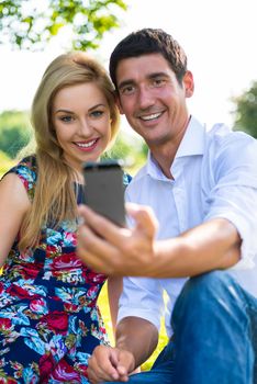 Couple taking selfie with phone in part