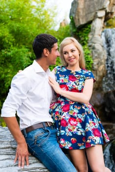 Man and woman embracing in summer park looking at each other being a couple