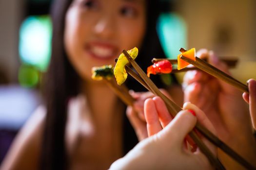 Young people eating in Asia restaurant