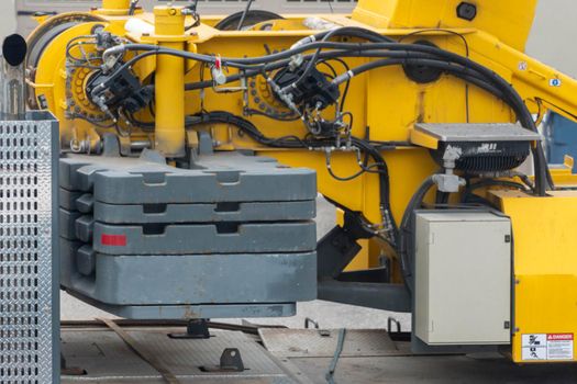 A fragment of hydraulic hoses and control tubes of the truck crane located on the side part next to the boom