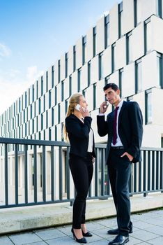 Business people working outdoors in city on bridge in front of office building