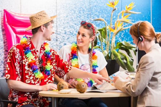 Man and woman booking holiday trip in travel agency