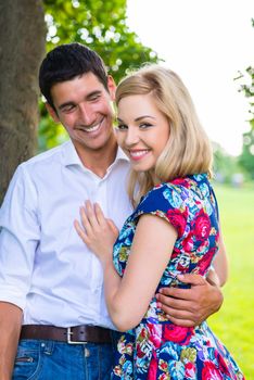 Man and woman embracing in park being couple in love