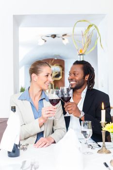 Business people, caucasian woman and african american man, toasting on deal with wine