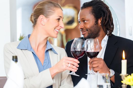 Business people, caucasian woman and african american man, toasting on deal with wine