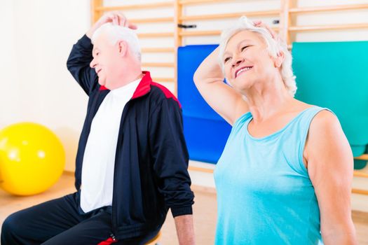 Senior people in fitness exercise doing gymnastic stretching