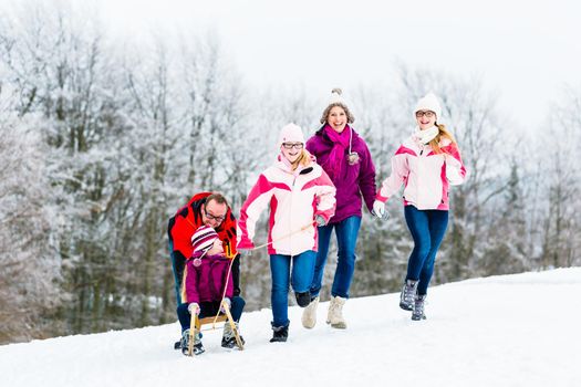 Family with kids having winter walk in snow