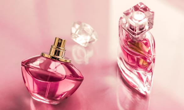 Perfumery, spa and branding concept - Pink perfume bottle on glossy background, sweet floral scent, glamour fragrance and eau de parfum as holiday gift and luxury beauty cosmetics brand design