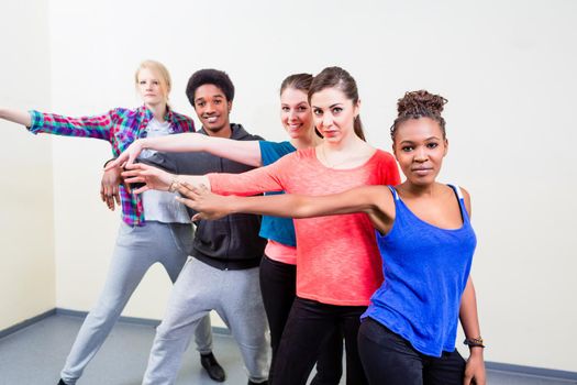 Group of happy young people having dance lessons