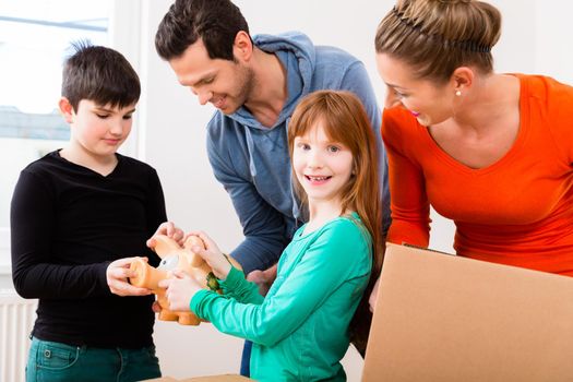 Family moving into new home carrying packing cases