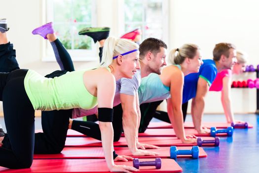 fitness people in gym working out with dumbbells