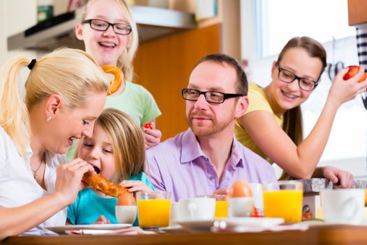 Family eating in kitchen having breakfast together