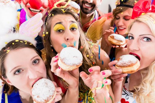 Carnival party people eating donuts on carnival party