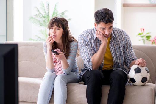 Family pair watching football at home