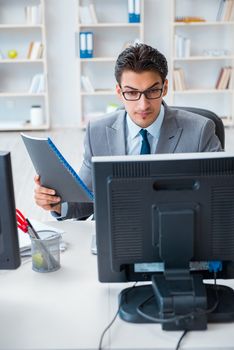 Businessman sitting in front of many screens