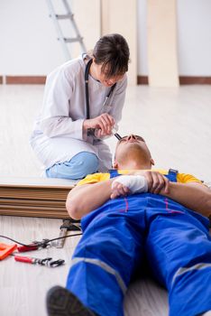 Doctor helping injured worker at construction site