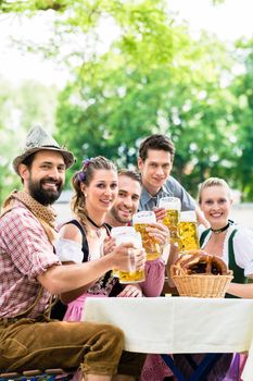 Friends in Bavarian beer garden drinking in summer