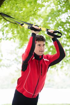 Man doing fitness sling training outdoors