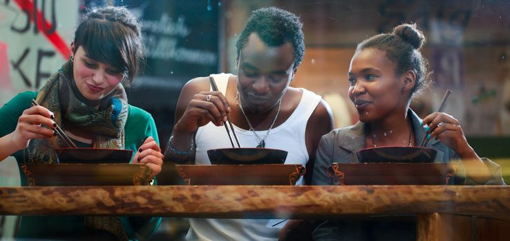 Man and women, black and Latin people, eating late in Korean eatery
