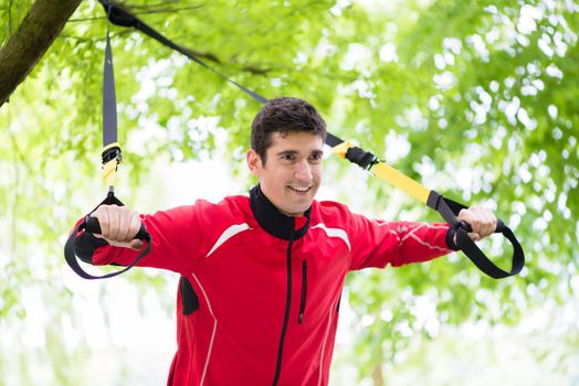 Man doing fitness sling training outdoors