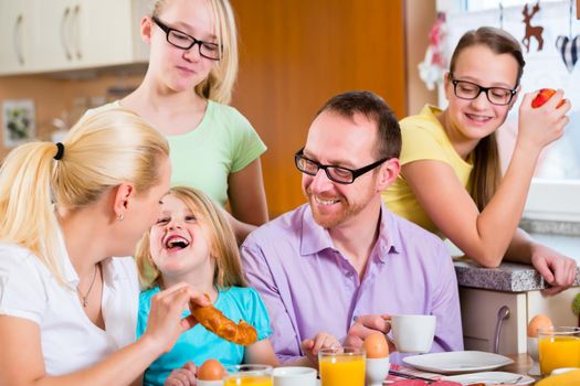 Family eating in kitchen having breakfast together