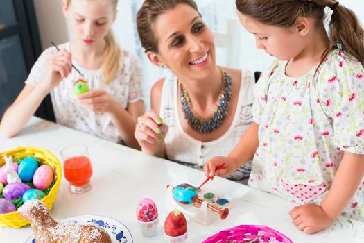 Family having fun coloring Easter eggs