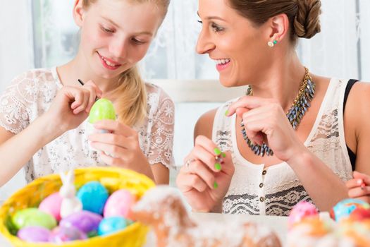 Family having fun coloring Easter eggs