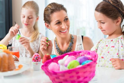 Family having fun coloring Easter eggs