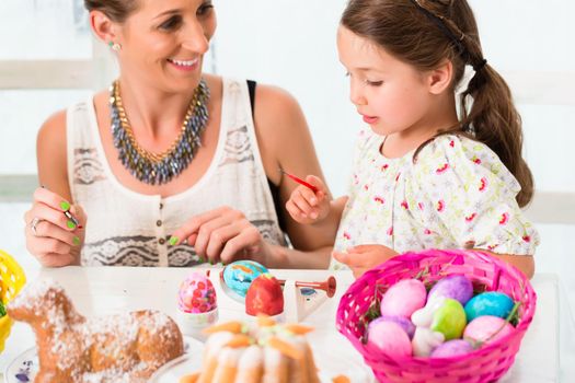 Family having fun coloring Easter eggs