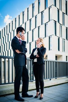 Business people working outdoors in city on bridge in front of office building