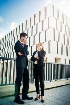 Business people working outdoors in city on bridge in front of office building