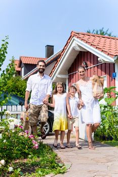 Family coming home from shopping groceries carrying bags