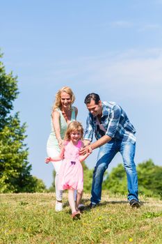 family playing catch or tag in summer outdoors