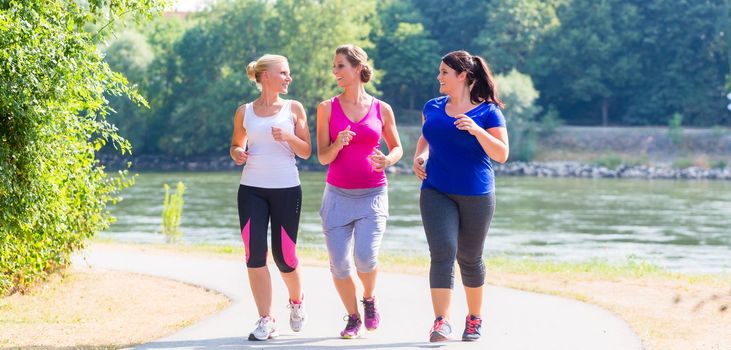 Group of women running at lakeside jogging