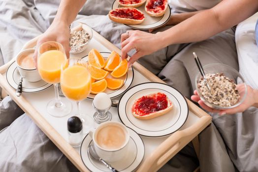 Close-up of romantic healthy breakfast with orange juice, jam, cereals and coffee