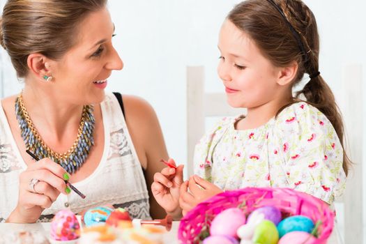 Family having fun coloring Easter eggs