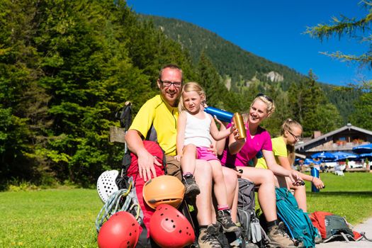 Happy family having break from hiking in the mountains