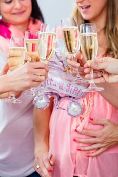 Friends clinking glasses on baby shower party, close-up shot on the sparkling wine