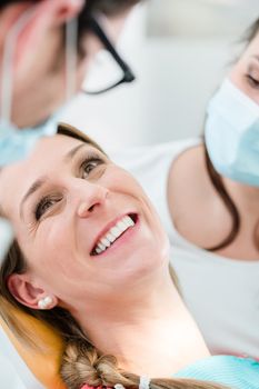 Woman with healthy smile at dentist after successful treatment