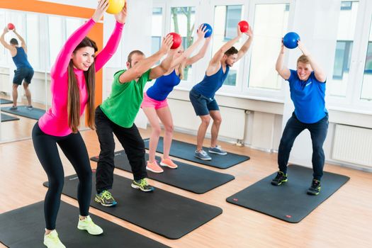 Young athletes doing gymnastics in health club gym