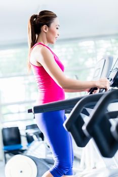 Sportive girl doing workout on treadmill