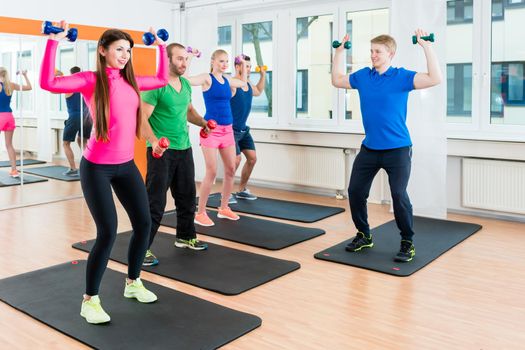 Young athletes doing gymnastics in health club gym