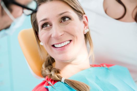 Woman with healthy smile at dentist after successful treatment